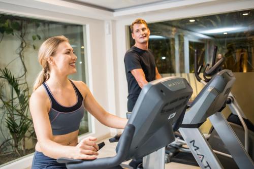 a man and a woman on a treadmill in a gym at Jimbaran Bay Beach Resort and Spa by Prabhu in Jimbaran