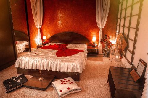 a bedroom with a large bed with a red wall at Hotel Roco in Izvin