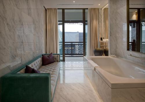 uma ampla casa de banho com uma banheira e um sofá em Diaoyutai Boutique Hotel Chengdu em Chengdu