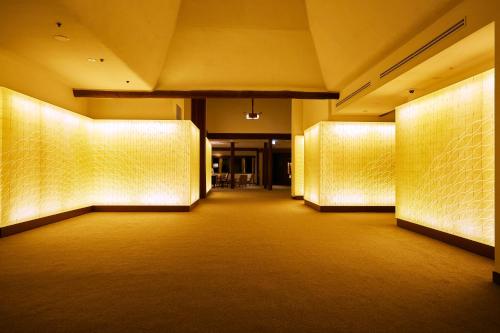 a hallway of a building with lights on the walls at Shima Kanko Hotel The Bay Suites in Shima