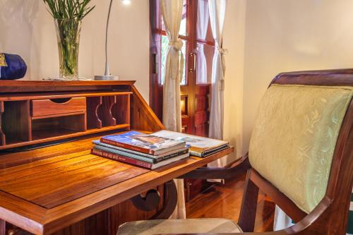 a wooden table with books on it with a chair at Mekong Riverview Hotel in Luang Prabang