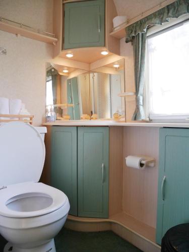 un bagno con un water e uno specchio di Samui Caravans a Laem Sor