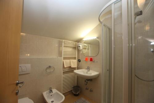 a bathroom with a sink and a toilet and a shower at Hotel Stampfer B&B in Laives