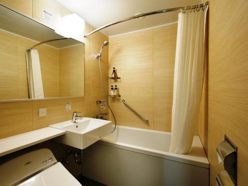 a bathroom with a sink and a tub and a shower at HATAGO INN Kansai Airport in Izumi-Sano