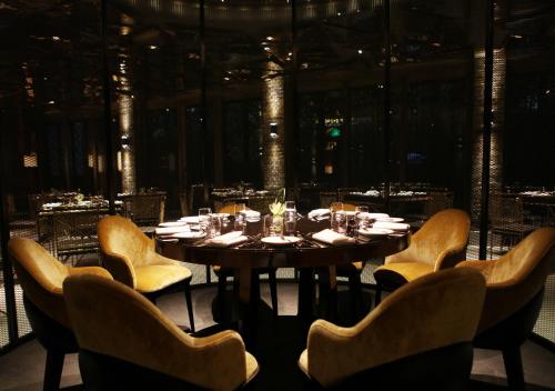 a dining room with a table with yellow chairs at Diaoyutai Boutique Hotel Chengdu in Chengdu