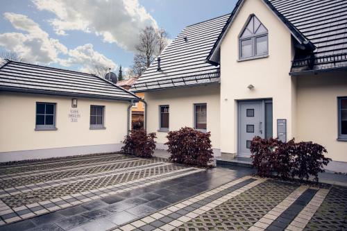 ein weißes Haus mit schwarzem Dach in der Unterkunft Casa Sellin - Apt. 01 in Ostseebad Sellin