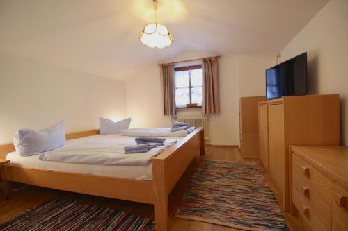 um quarto com uma cama e uma televisão de ecrã plano em Carina, Martin, Michael & Sissi em Garmisch-Partenkirchen
