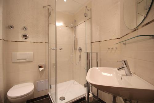 uma casa de banho com um chuveiro, um lavatório e um WC. em Carina, Martin, Michael & Sissi em Garmisch-Partenkirchen