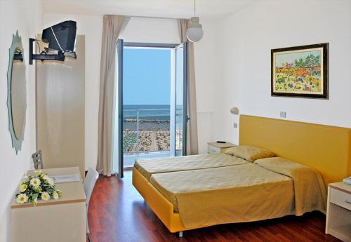 a hotel room with a bed and a large window at Hotel Majestic in Pesaro