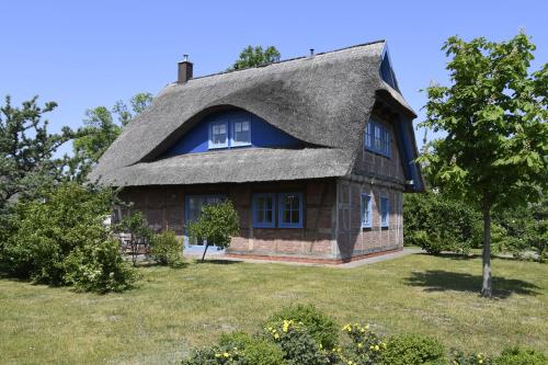 una casa con techo de paja en un campo en Fachwerkhäuser Gager Haus „Strate“, en Gager