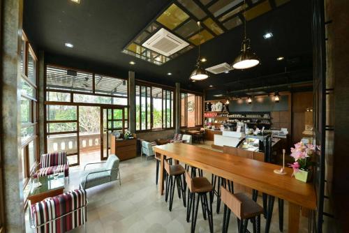 ein Restaurant mit einem großen Holztisch und Stühlen in der Unterkunft Doithinnan Resort in Nan