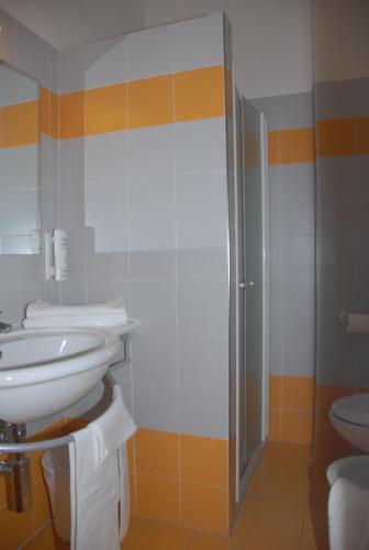 a bathroom with a toilet and a sink and a shower at Hotel Majestic in Pesaro