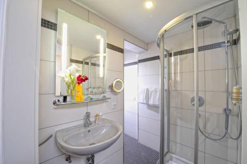 uma casa de banho com um lavatório e um chuveiro em Natur- und Sporthotel Zuflucht em Freudenstadt