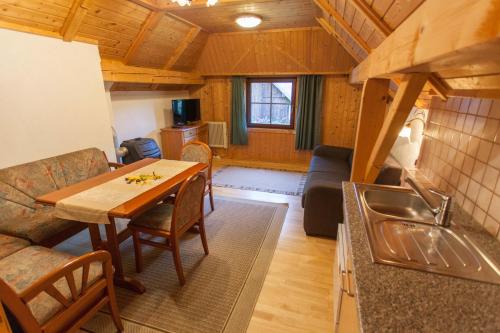 a kitchen and living room with a table in a room at Bodnerhof in Arriach