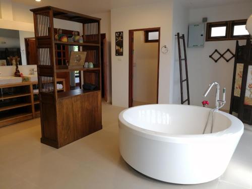 a large white bath tub in a room at Jasmine Hills Lodge in Doi Saket