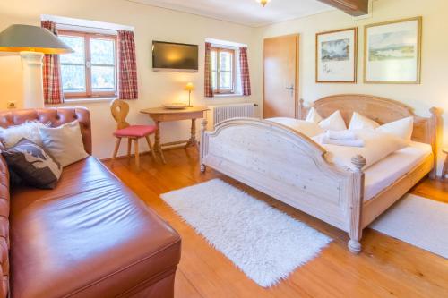 sala de estar con cama grande y sofá en Berggasthof Butzn Wirt en Ruhpolding