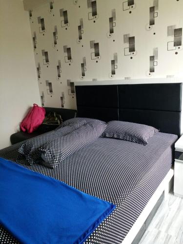 Un dormitorio con una cama con un edredón azul. en Suites Metro Bandung - Aloha, en Bandung