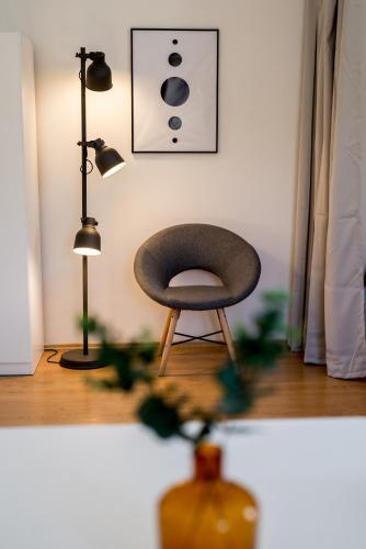 a chair sitting in a room with a lamp at Apartmán v centru in Šumperk