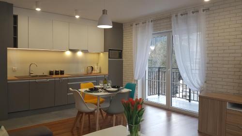a kitchen with a table and chairs and a window at Apartament Juzo in Szklarska Poręba