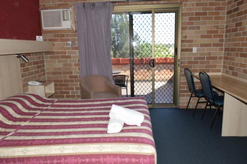 ein Hotelzimmer mit einem Bett und einem Balkon in der Unterkunft Windsor Terrace Motel in Windsor