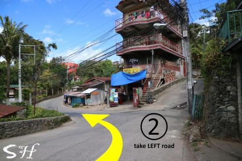 a street with a building on the side of the road at Small House - Baguio in Baguio