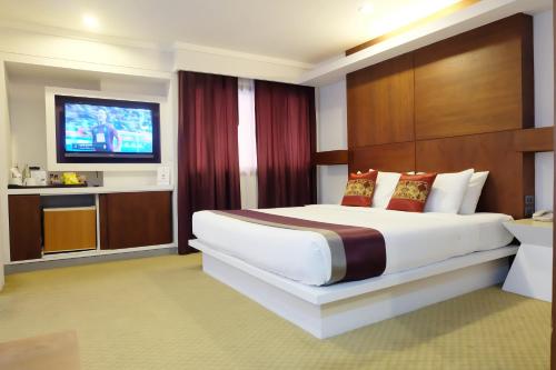 a hotel room with a bed and a flat screen tv at Star Hotel Chiang Mai - SHA Extra Pus in Chiang Mai
