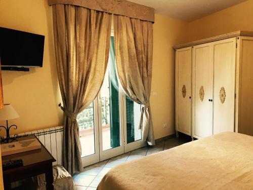 タオルミーナにあるLa casa di Marilenaのベッドルーム1室(ベッド1台、大きな窓付)