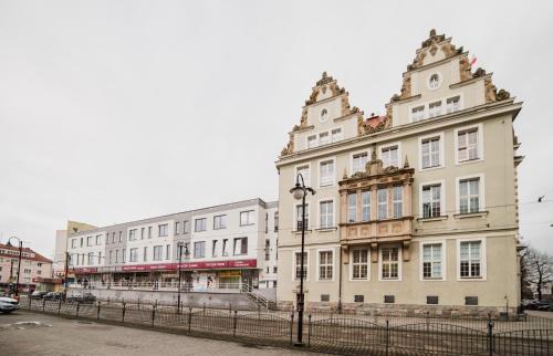 a large white building on a city street at Apartamenty 1 Maja 45 in Elblag