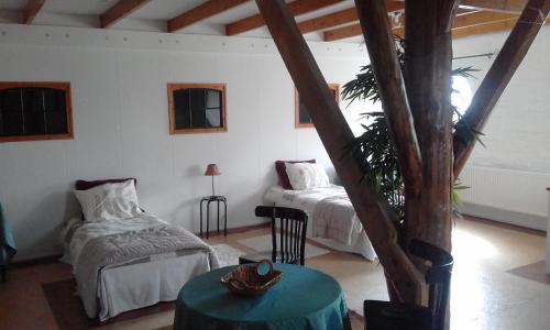 a room with two beds and a table in it at Theaterwerkplaats private appartment in Kantens