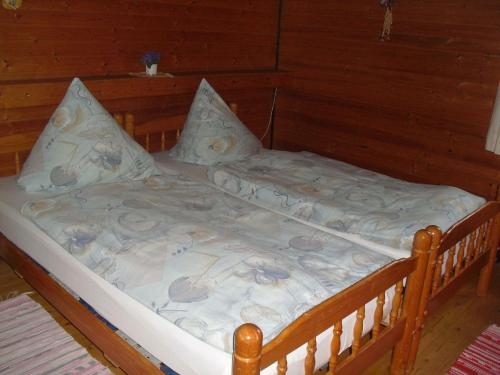 a bed in a room with a wooden wall at Ferienhaus Schallerhof in Kupferberg