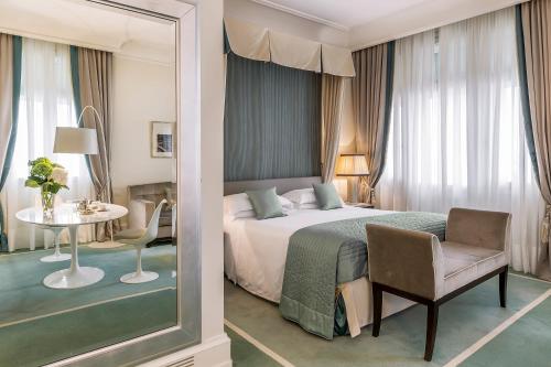 um quarto com uma cama, uma mesa e uma cadeira em Savoia Excelsior Palace Trieste - Starhotels Collezione em Trieste