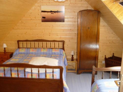 カマレ・シュル・メールにあるle moign-locationsの木製の壁のベッドルーム1室(ベッド1台付)