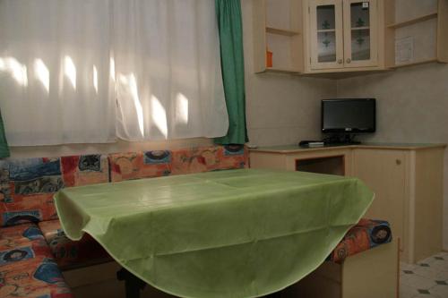 a living room with a couch with a green tub at La Pineta in Albenga