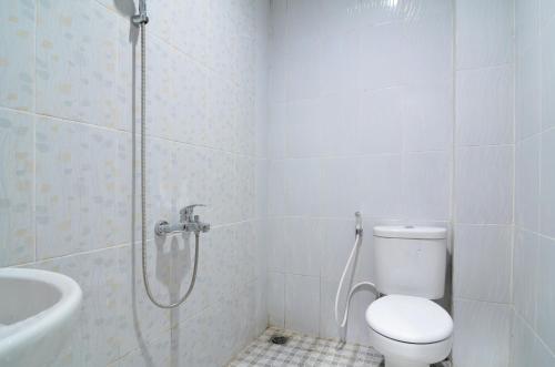 a bathroom with a shower and a toilet and a sink at RedDoorz near Museum Keraton Surakarta in Solo