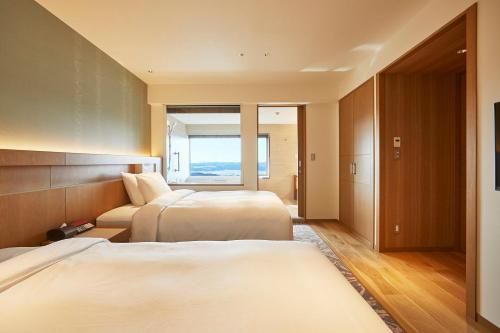 um quarto de hotel com duas camas e uma janela em Shima Kanko Hotel The Classic em Shima