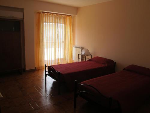 una camera da letto con due letti e una finestra di Casa dei Girasoli - Formia centro a Formia