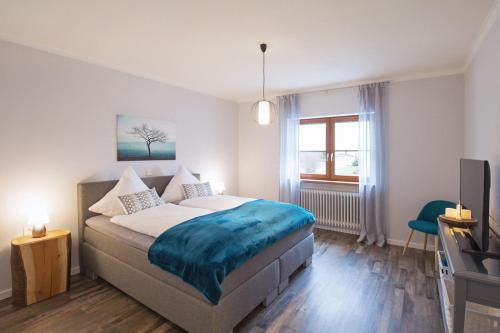 1 dormitorio con 1 cama, TV y ventana en Ferienwohnung Landblick, en Niederlinxweiler