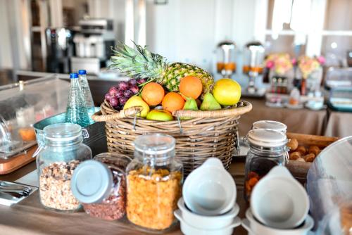 Una cesta de fruta sobre una encimera junto con otros alimentos. en Hotel Oromana, en Alcalá de Guadaira