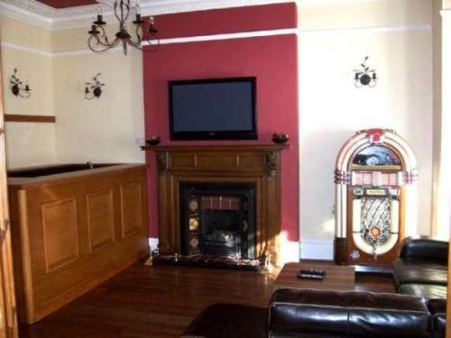 a living room with a fireplace with a flat screen tv at Kingsley Hotel in Bournemouth