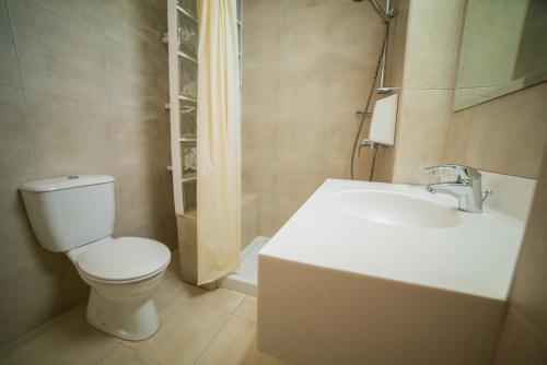 a bathroom with a white toilet and a sink at MyroAndrou Beach Hotel Apartments in Protaras