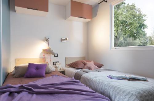 Un ou plusieurs lits dans un hébergement de l'établissement Lagrange Grand Bleu Vacances - Camping de l'Arquet