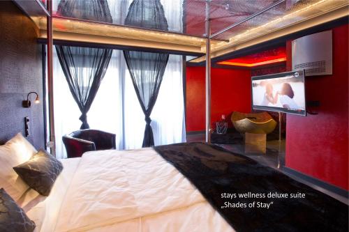 a bedroom with a large bed and a tv in it at PLAZA INN stays design Dortmund in Dortmund