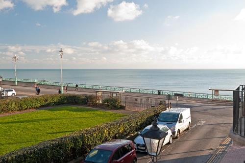 a parking lot with cars parked next to the beach at Hamptons Brighton in Brighton & Hove