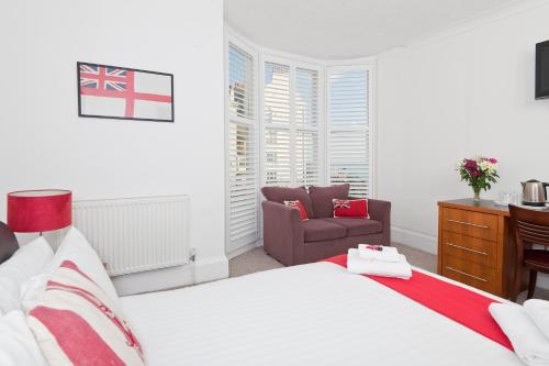 a bedroom with a bed and a chair at Hamptons Brighton in Brighton & Hove