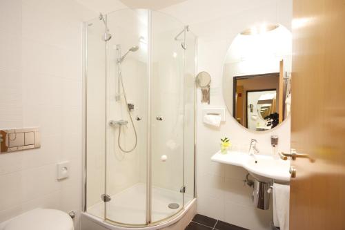 a bathroom with a shower, sink, and toilet at Ambra Hotel in Budapest