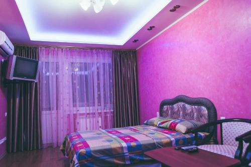 Habitación de color rosa con cama y TV en Prime Home en Chernihiv