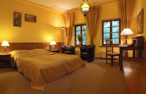 a bedroom with a bed and chairs and windows at Dom Casimi in Krakow