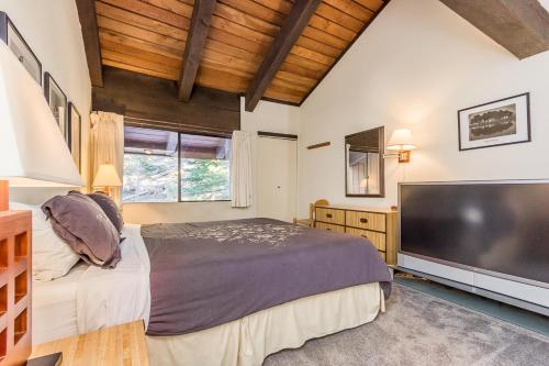 1 dormitorio con 1 cama grande y TV de pantalla plana grande en Mammoth Ski and Racquet 132 en Mammoth Lakes