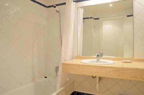 タマリウにあるGala 4のバスルーム(シンク、鏡、バスタブ付)