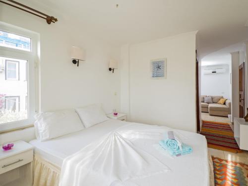 a white bedroom with a white bed and a window at Hideaway in Kas
